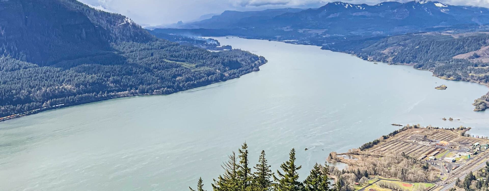 A panoramic view of a river winding through lush landscapes and mountains.