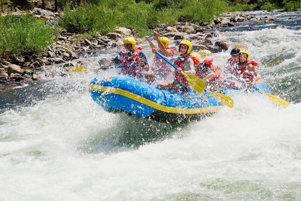 A group of people enjoying white-water rafting on a river.