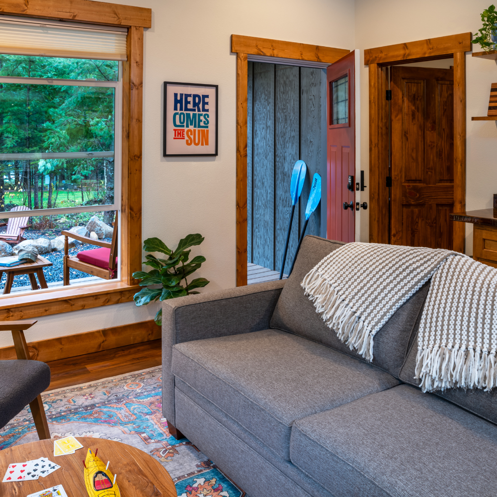 Image of loveseat and and accommodations with a view of the Cascade forest out the window at Backwoods Cabins in Carson, Washington