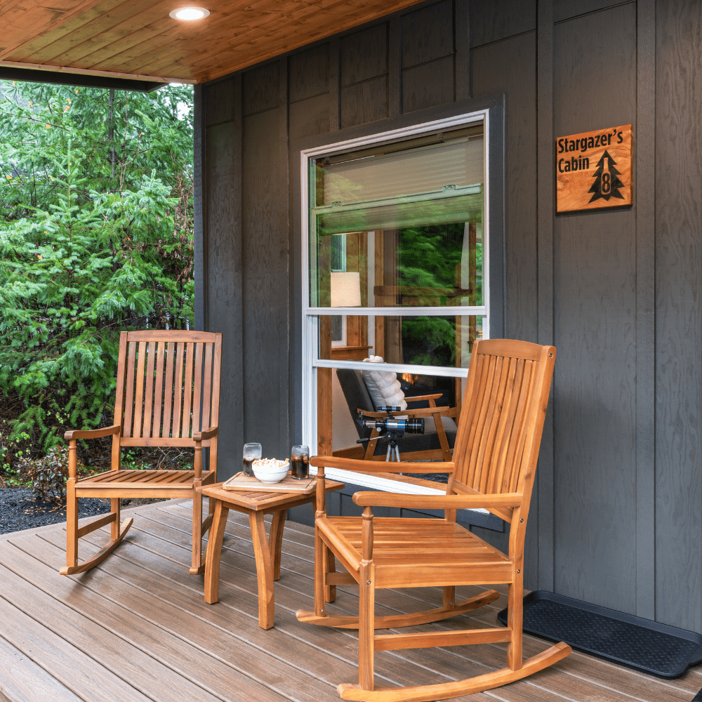 Image of front porch of Cabin with two rocking chairs and wood table with popcorn and soda